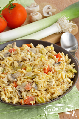 Medium bowl of a saucy orzo dish with vegetables.
