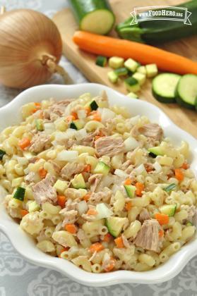 Bowl of macaroni noodles with tuna and vegetable cubes.