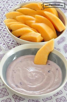 Bowl of yogurt dip served with cantaloupe slices. 