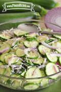 Bowl of seasoned zucchini and red onion slices. 
