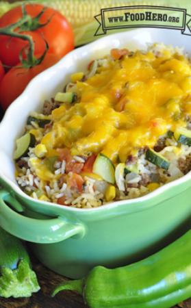 Casserole dish with melted cheese coating a rice and vegetable mix. 