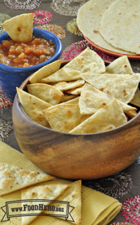 A bowl of baked tortilla chips is shown with salsa for dipping.