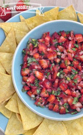 Bowl of bright green and red Strawberry Salsa served with tortilla chips. 