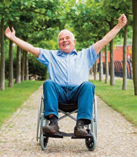 older man in wheelchair raising arms
