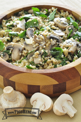 A wooden bowl with bulgur, mushrooms and spinach.