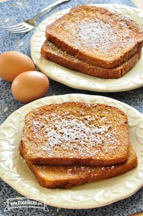 Plates of French Toast dusted with powdered sugar.