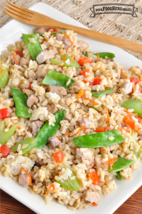 Plato colorido de arroz salteado, cerdo y verduras con glaseado de salsa de soya.