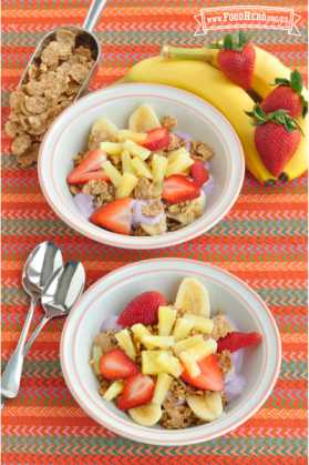 Tazones pequeños de yogur cubiertos con cereal y una colorida combinación de frutas.