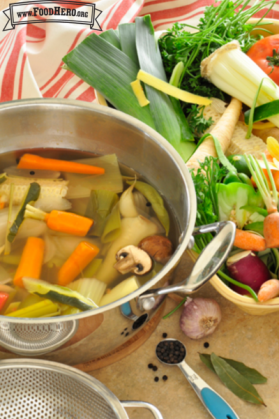 Pot full of water with vegetables and herbs.