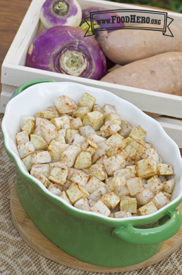 Baking dish filled with sweet potatoes and turnips sprinkled with cinnamon.