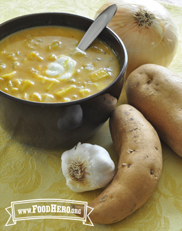 Bowl of orange, creamy soup with a dallop of sour cream 