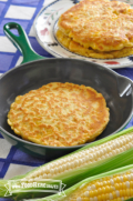 Panqueques de maíz dorados y redondos  en un sartén y un plato.