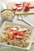 Bowl of oats served with sliced strawberries.