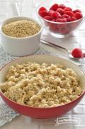 Bowl of soft textured oats served with raspberries.