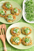 Plate of vegetable and potato patties served with a creamy sauce and microgreens on top.