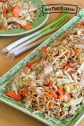 Plate of stir-fried noodles with chicken and vegetables.