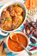 Bowl of thin red salsa shown drizzled over chicken and vegetables.