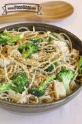 Bowl of noodles, broccoli and chicken with a light sauce and sesame seeds.