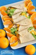 Platter of tortillas filled with lettuce, chicken and oranges. 