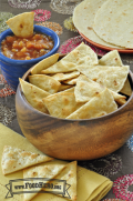 A bowl of baked tortilla chips is shown with salsa for dipping.