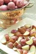 Plate of baked red potato quarters.