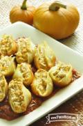 Plate of pasta shells filled with pumpkin and cheese filling over red pasta sauce.