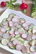 Platter of thinly sliced cucumbers and radishes with a seasoned yogurt sauce.