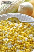 Bowl of sauteed corn and small onion pieces.