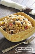 A seasoned mix of brown rice, black beans and corn is shown in a serving bowl.