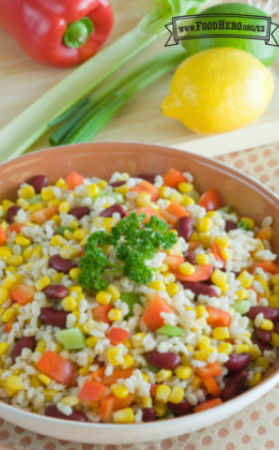 Un tazón de ensalada de cebada, frijoles y verduras adornada con perejil.