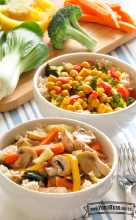 Dos tazones con arroz y una variedad de verduras salteadas.