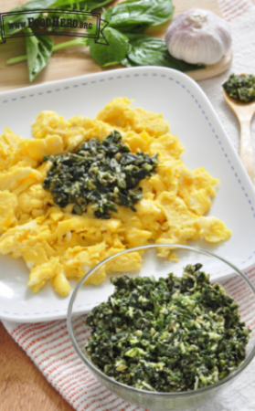 Small bowl of pesto served with scrambled eggs.