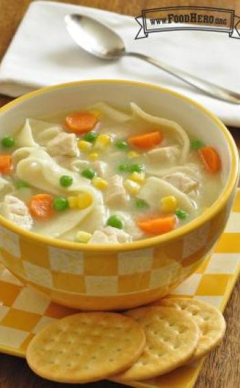 Bowl of chicken noodle soup served with crackers. 