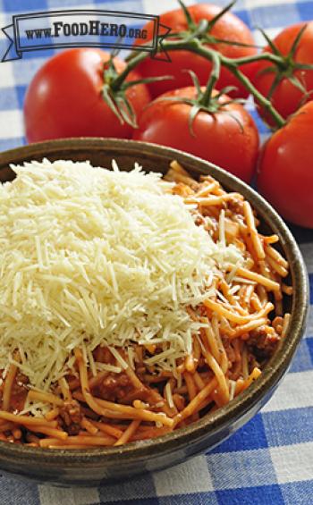 Big bowl of spaghetti topped with grated parmesan cheese.